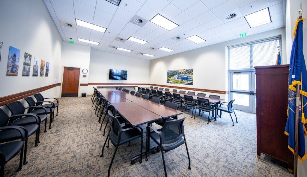 Conference tables and chairs arranged for discussion in the Olmsted Room at the Utah State Capitol