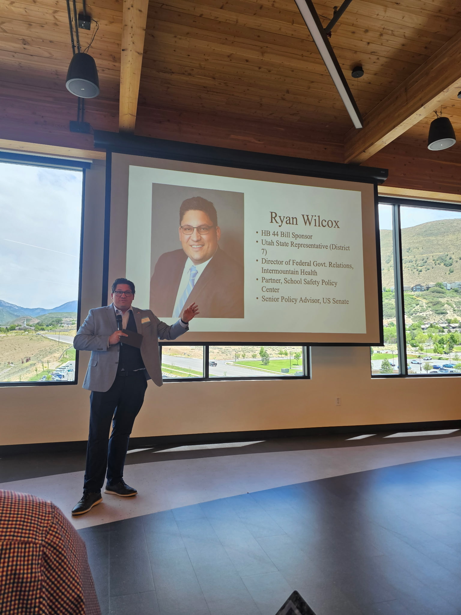 A speaker presents a slide covering HB 44 and its sponsor, Rep. Ryan Wilcox