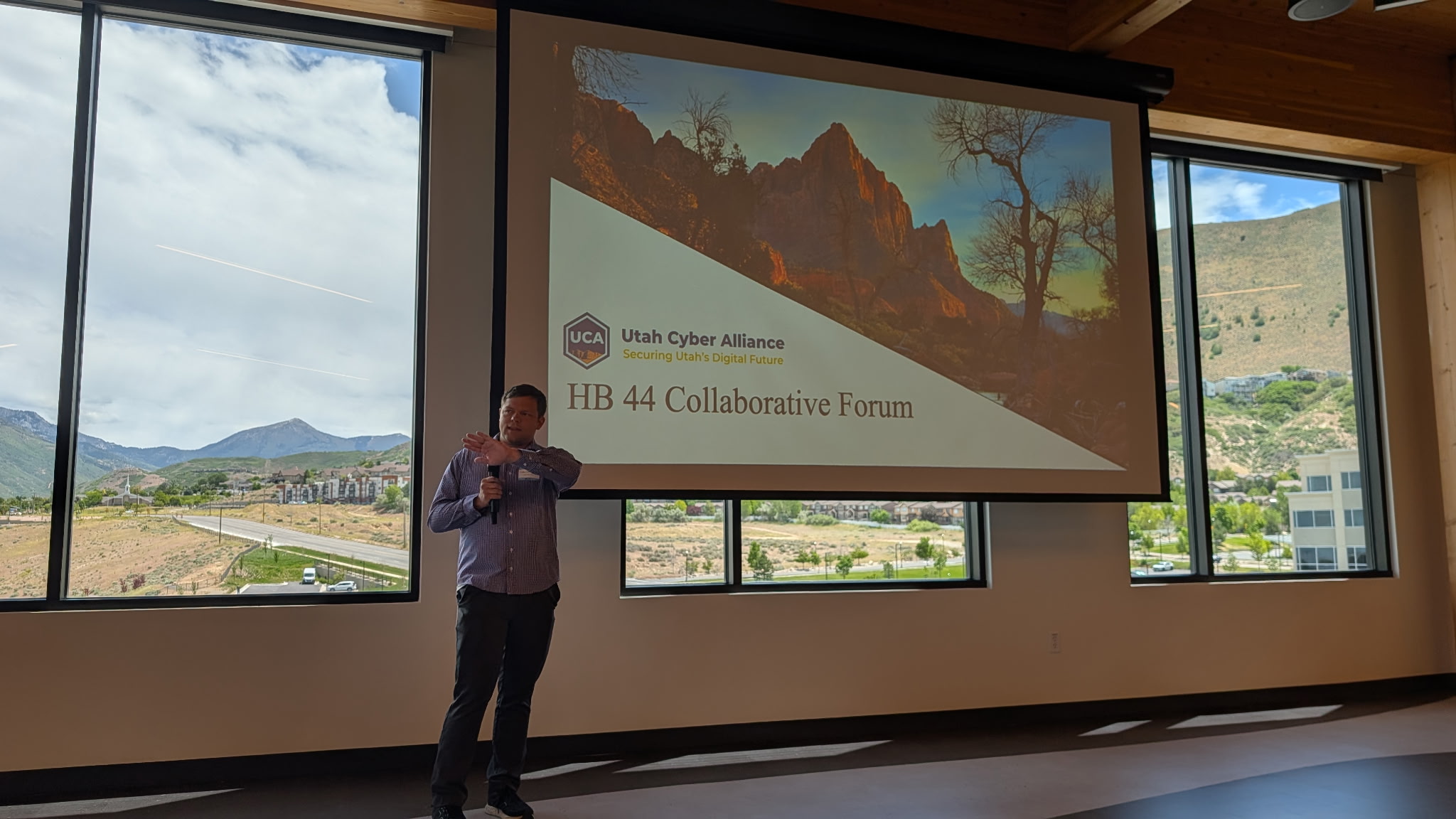 A speaker opens the HB 44 Collaborative Forum in front of a Utah Cyber Alliance title slide